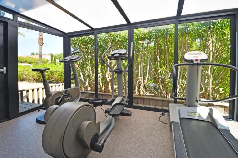 Salle de gym avec tapis et vélos d'exercice.