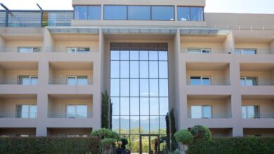 Façade d'un hôtel moderne avec balcons et vitres.