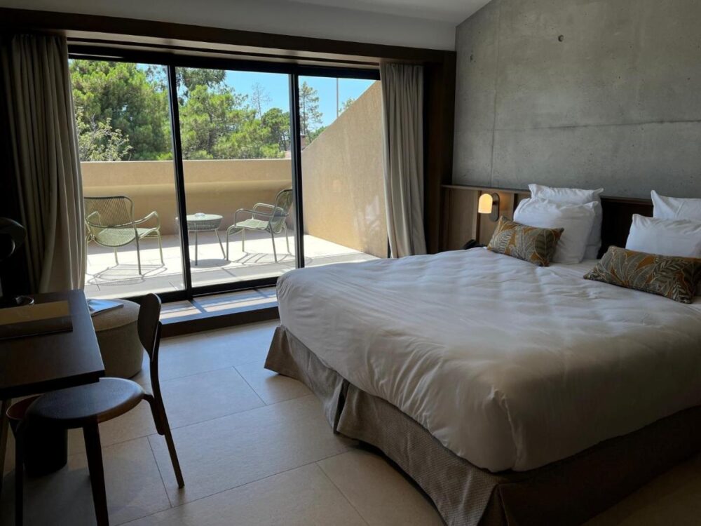 Chambre d'hôtel moderne avec terrasse ensoleillée.