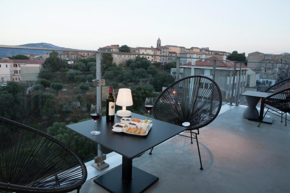 Terrasse avec vue, table et vin rouge.