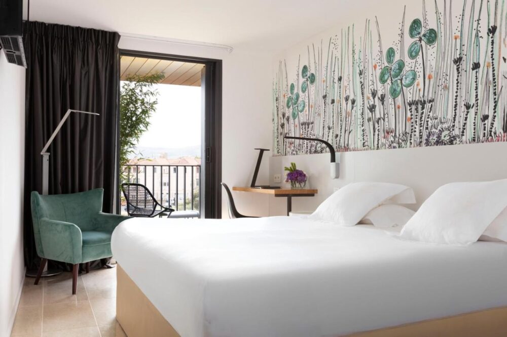 Chambre d'hôtel moderne avec balcon et décoration murale.
