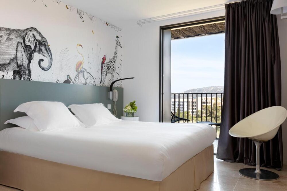 Chambre avec lit double et fresque murale d'animaux.
