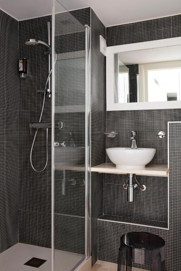 Salle de bain moderne avec douche et lavabo blanc.