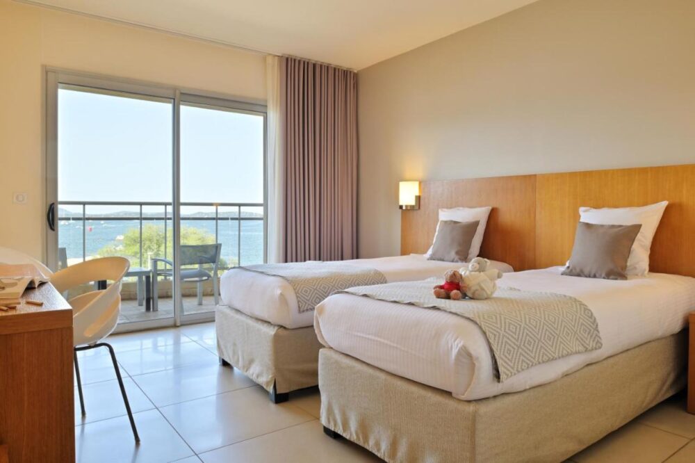 Chambre d'hôtel avec lits jumeaux, vue sur mer.