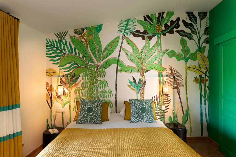 Chambre exotique avec décor mural végétal.