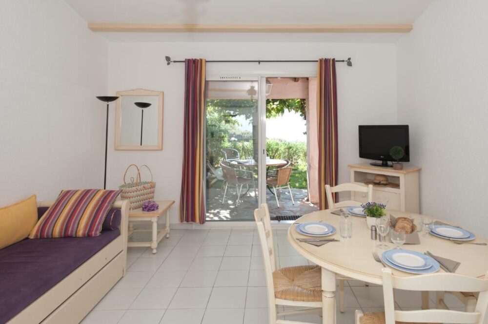 Salle à manger lumineuse avec baie vitrée et terrasse.