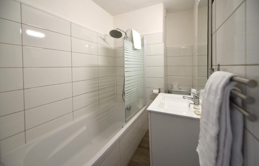 Salle de bain moderne avec baignoire et lavabo.