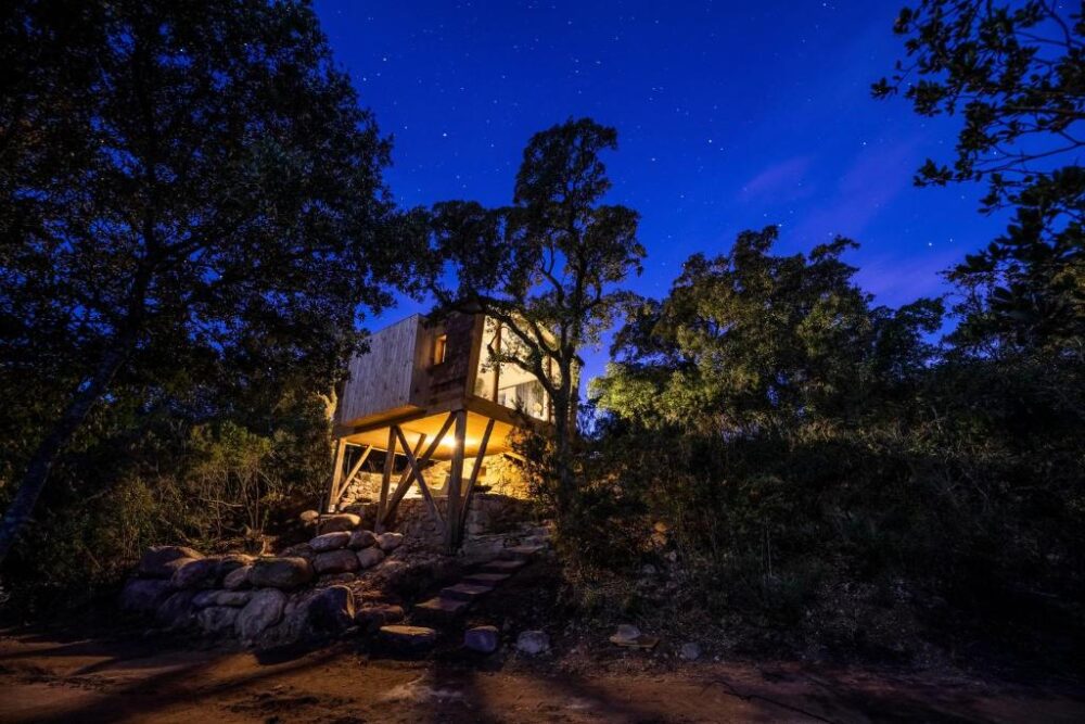 Cabane éclairée sous un ciel étoilé.