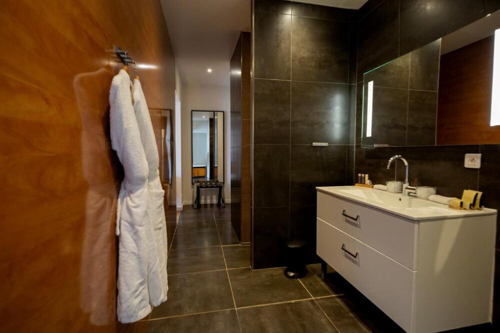 Salle de bain moderne avec peignoir blanc.