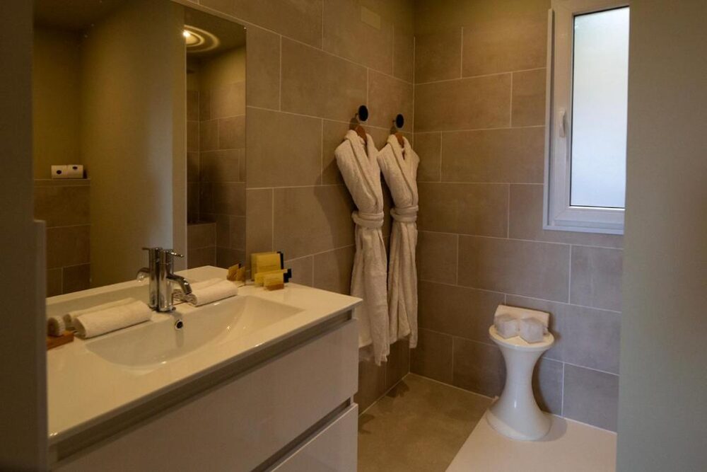 Salle de bain moderne avec peignoirs suspendus.