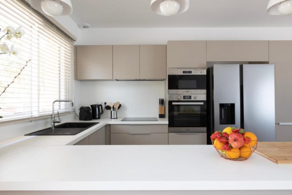 Cuisine moderne avec électroménagers et fruits.