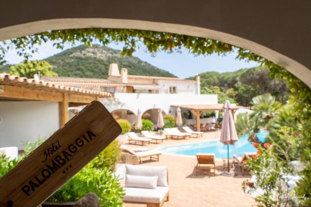 Hôtel avec piscine et terrasse ensoleillée.