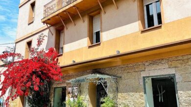 Hôtel avec façade et balcon fleuri.