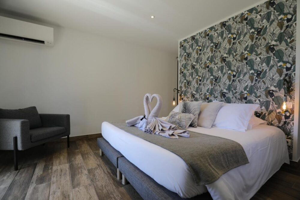Chambre avec lit décoré et papier peint floral.
