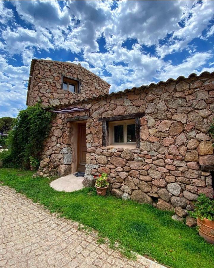 Maison en pierre sous ciel nuageux.