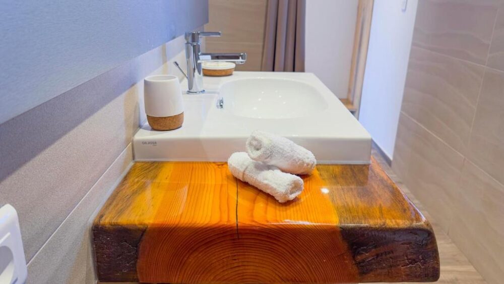 Lavabo moderne avec serviettes blanches pliées.
