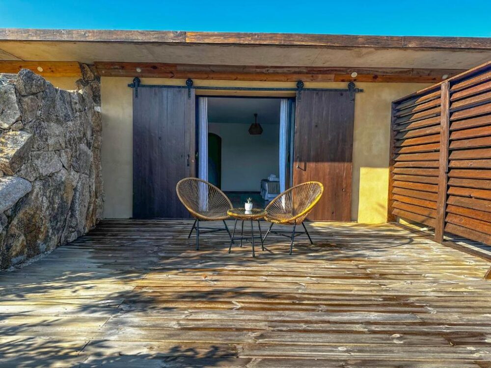 Terrasse en bois avec sièges et table extérieure.