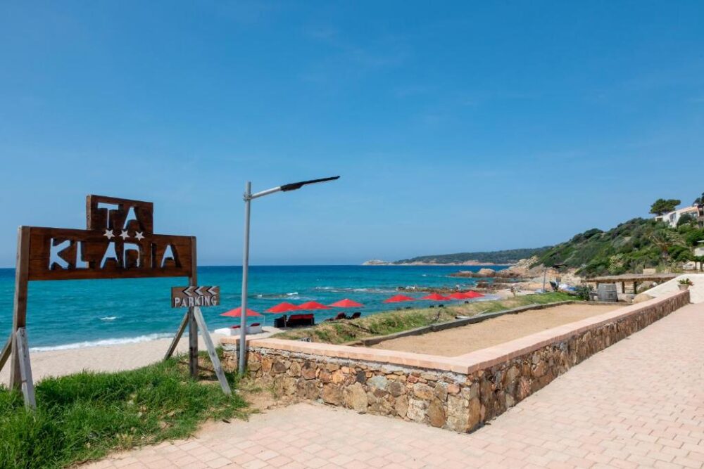 Plage avec parasols et panneau de parking.