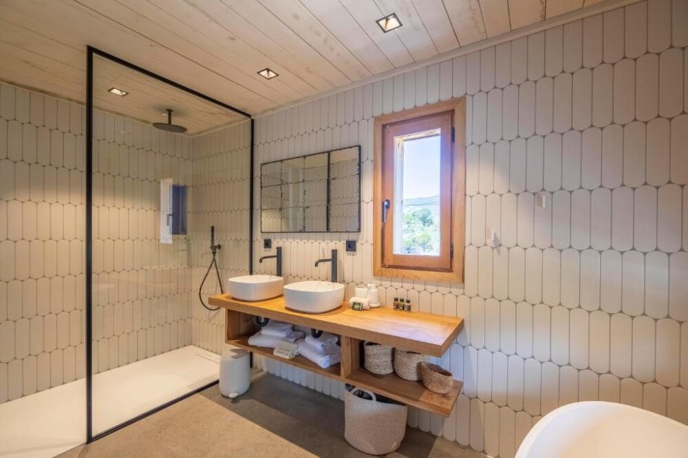 Salle de bain moderne avec douche et double vasque.