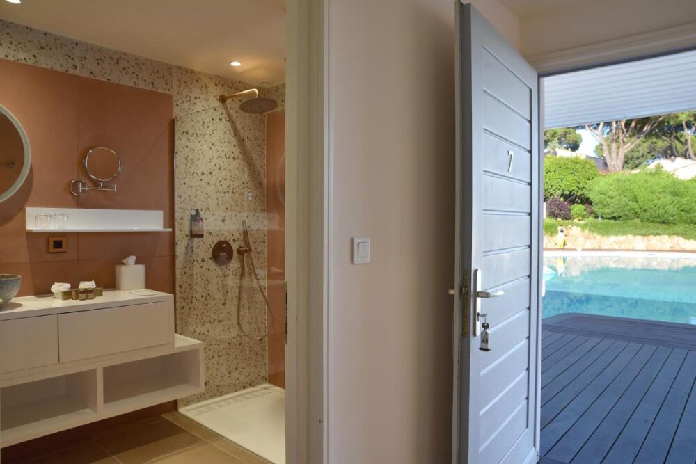 Salle de bain ouverte sur piscine extérieure.