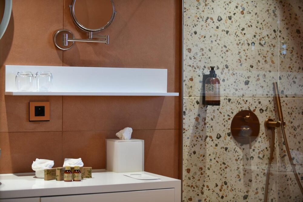 Salle de bain moderne avec douche et accessoires.