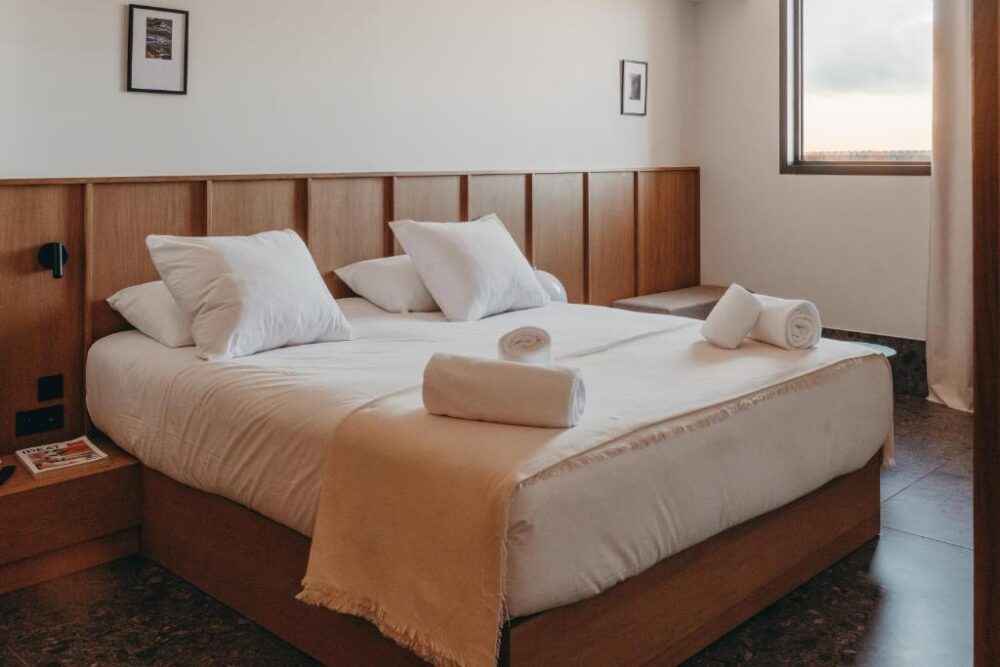 Chambre d'hôtel avec lit double, fenêtre.