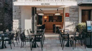 Terrasse de café moderne avec tables et chaises noires.