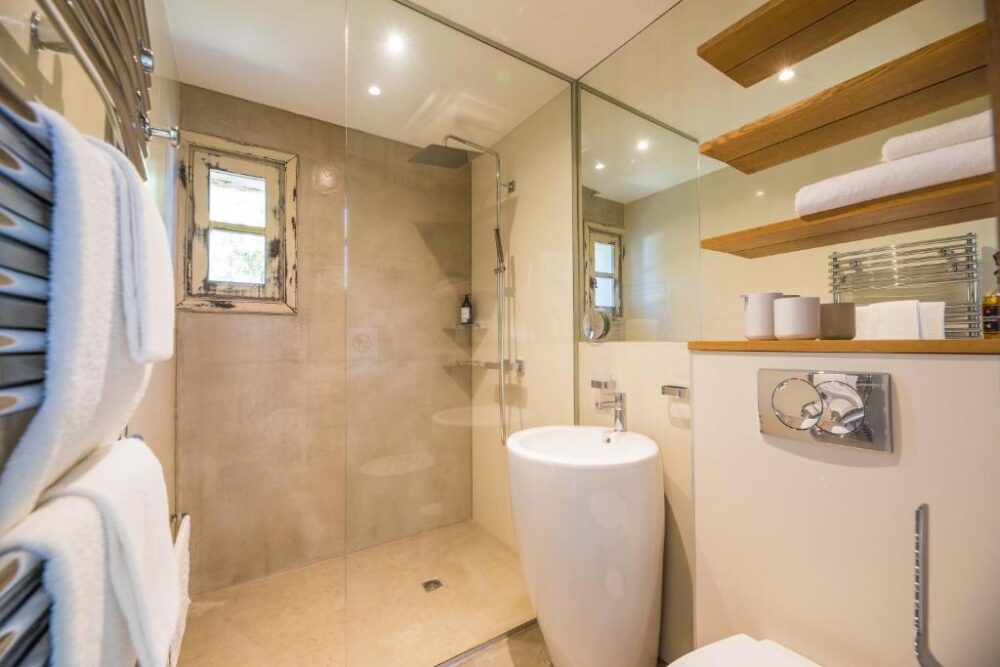 Salle de bain moderne avec douche et lavabo design.