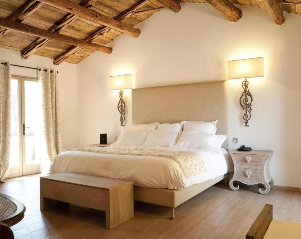 Chambre lumineuse avec lit double et plafond en bois.
