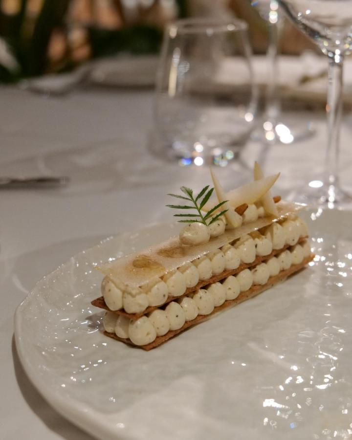 Dessert pâtisserie raffinée sur assiette blanche élégante.