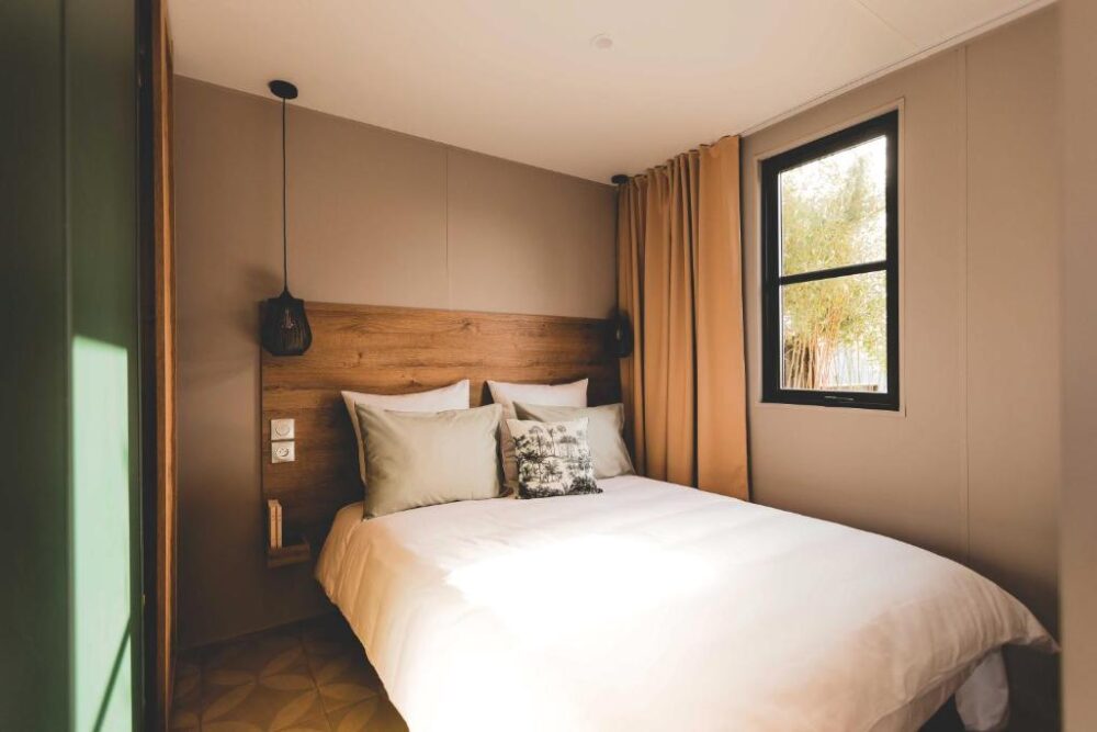 Chambre double lumineuse et moderne avec fenêtre.