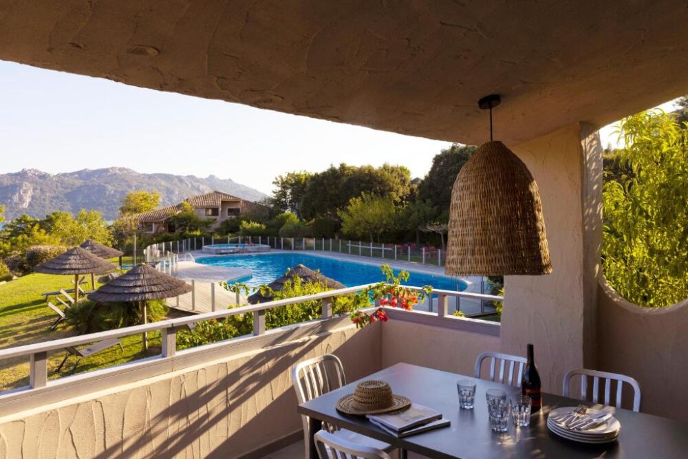 Terrasse surplombant piscine et montagnes.