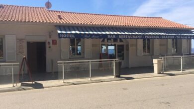 Hôtel avec restaurant et bar, façade bleue et blanche.