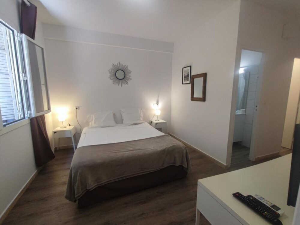 Chambre moderne avec lit double et éclairage doux.
