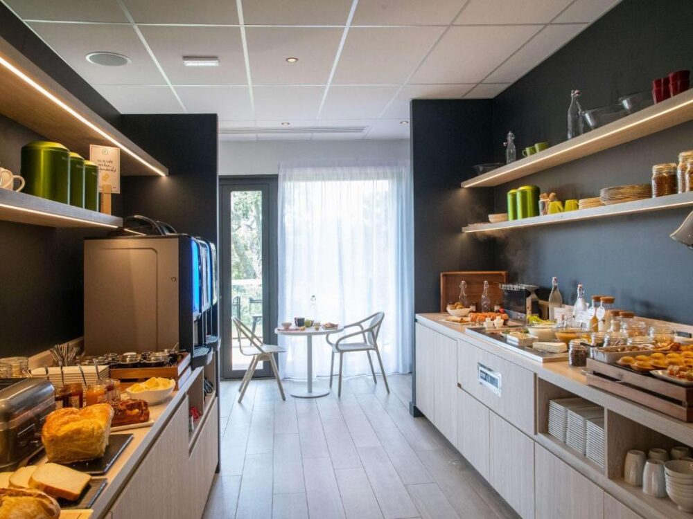 Buffet petit déjeuner varié dans salle lumineuse.