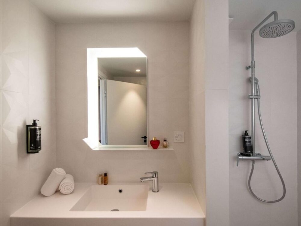 Salle de bain moderne avec douche et lavabo.