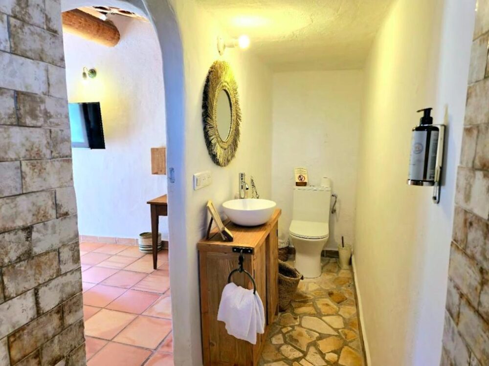 Salle de bain rustique avec lavabo et toilettes.