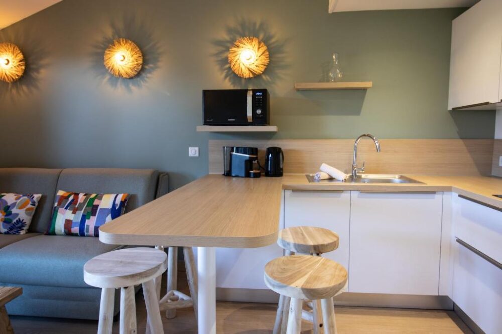 Cuisine moderne avec bar et canapé coloré.