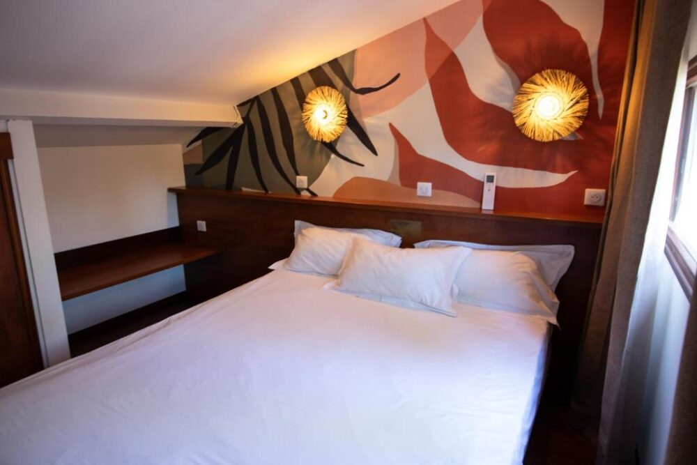 Chambre avec lit double, décor mur coloré.
