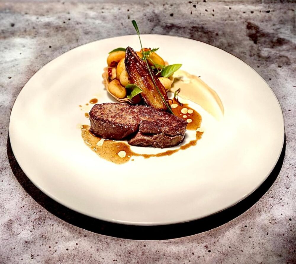 Plat gourmet avec viande et légumes.