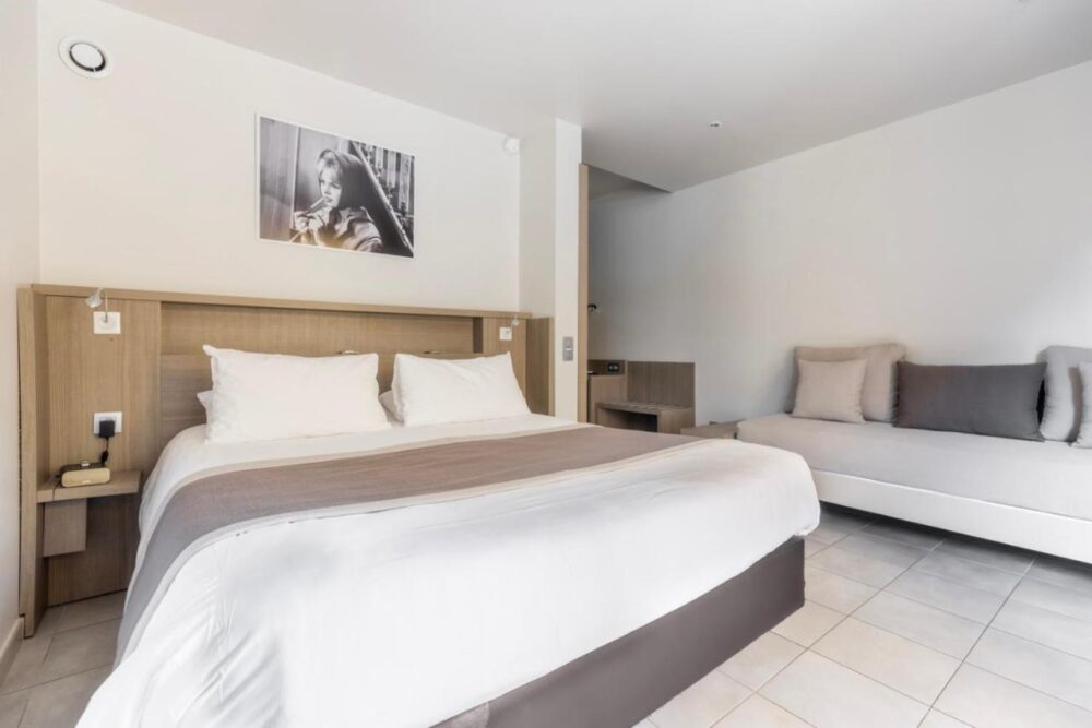 Chambre moderne avec lit double et canapé.