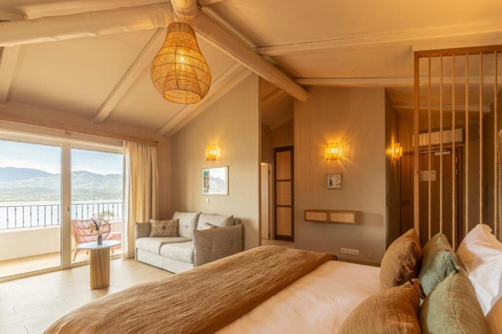 Chambre lumineuse avec balcon et vue sur montagnes.