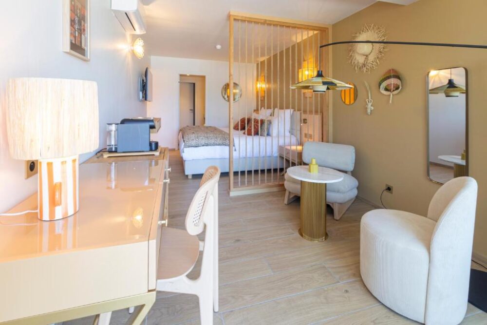 Chambre d'hôtel moderne avec bureau et fauteuils.