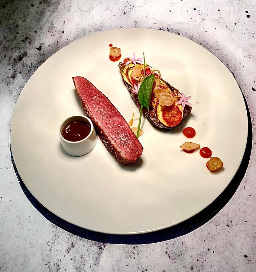 Plat gourmet avec viande et garniture élégante.