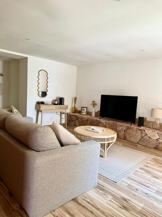 Salon moderne avec canapé et télévision.