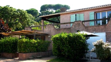 Villa en pierre avec jardin verdoyant.