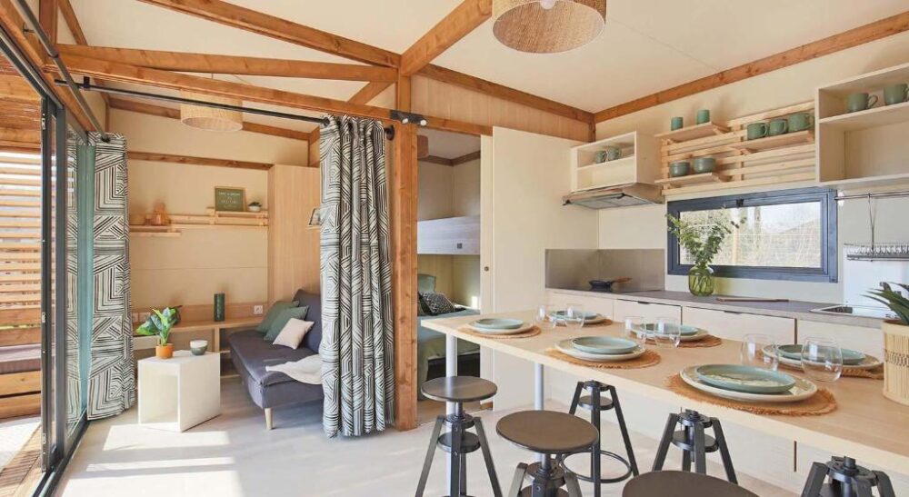 Salon-cuisine bois clair avec table dressée.