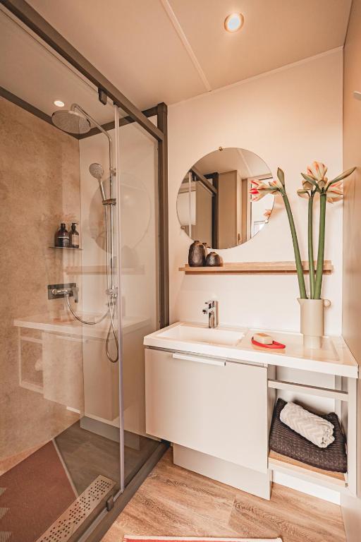 Salle de bain moderne avec douche et lavabo.