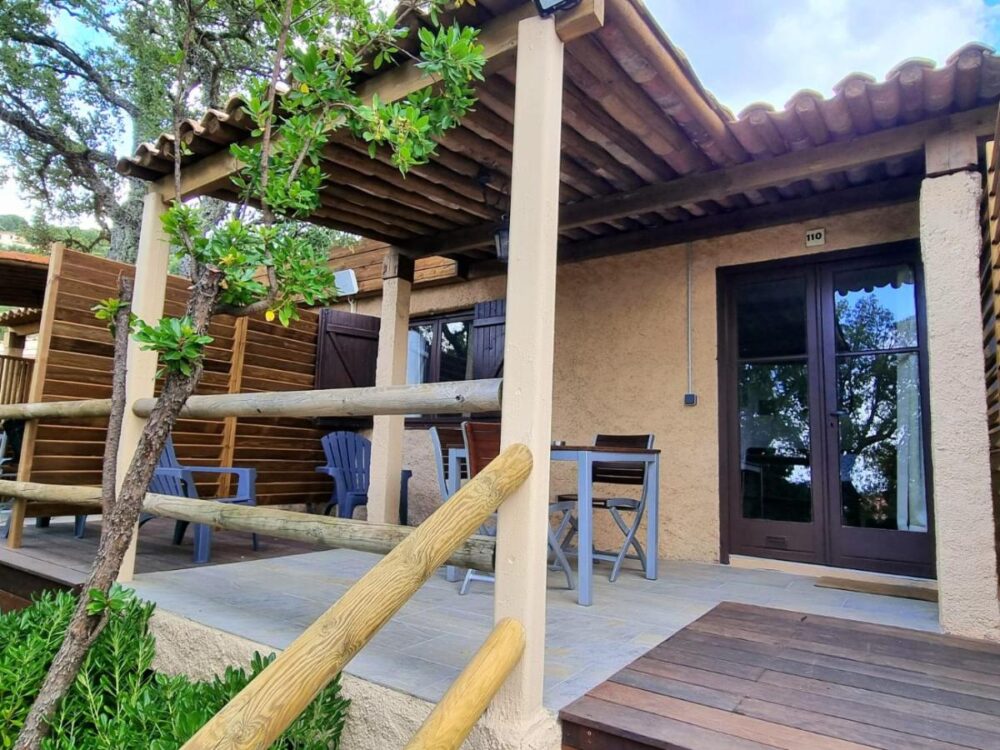 Terrasse en bois avec chaises et table extérieure.