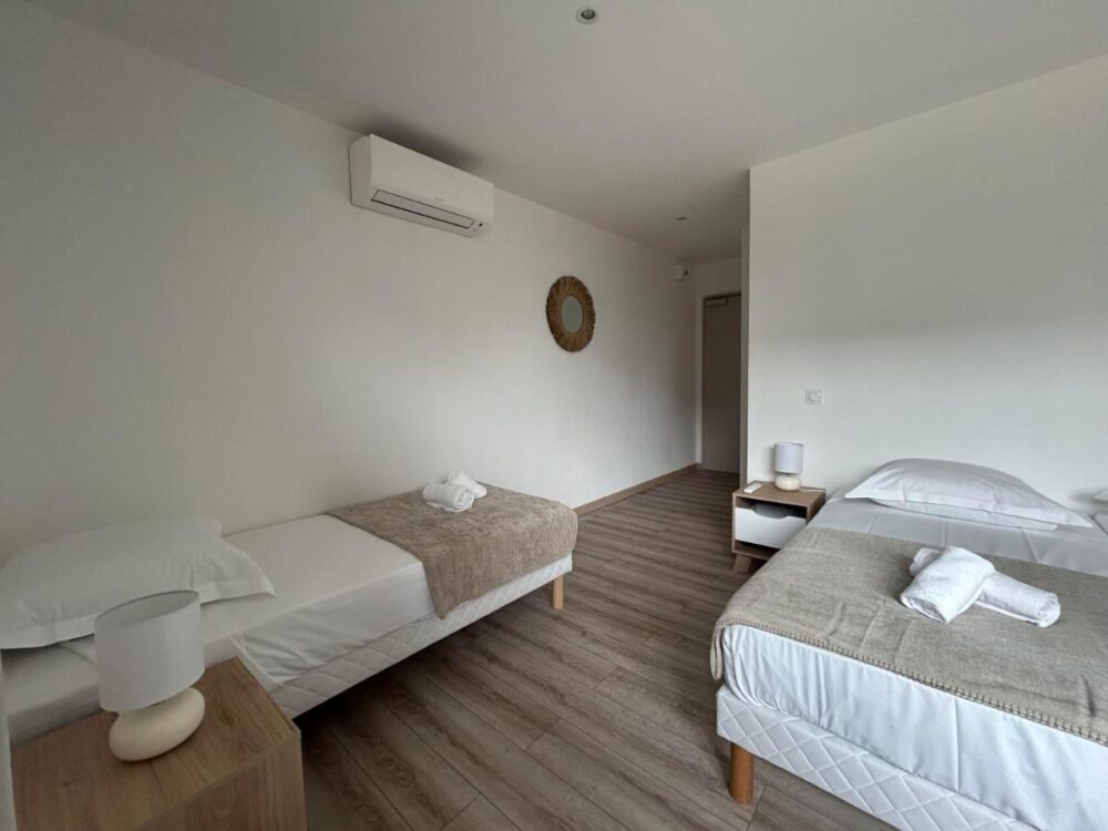 Chambre avec deux lits simples et décoration moderne.